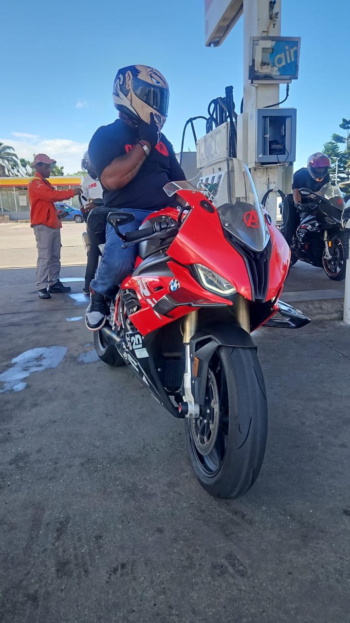 Red BMW S1000RR at a fuel stop with an Alpha Team rider