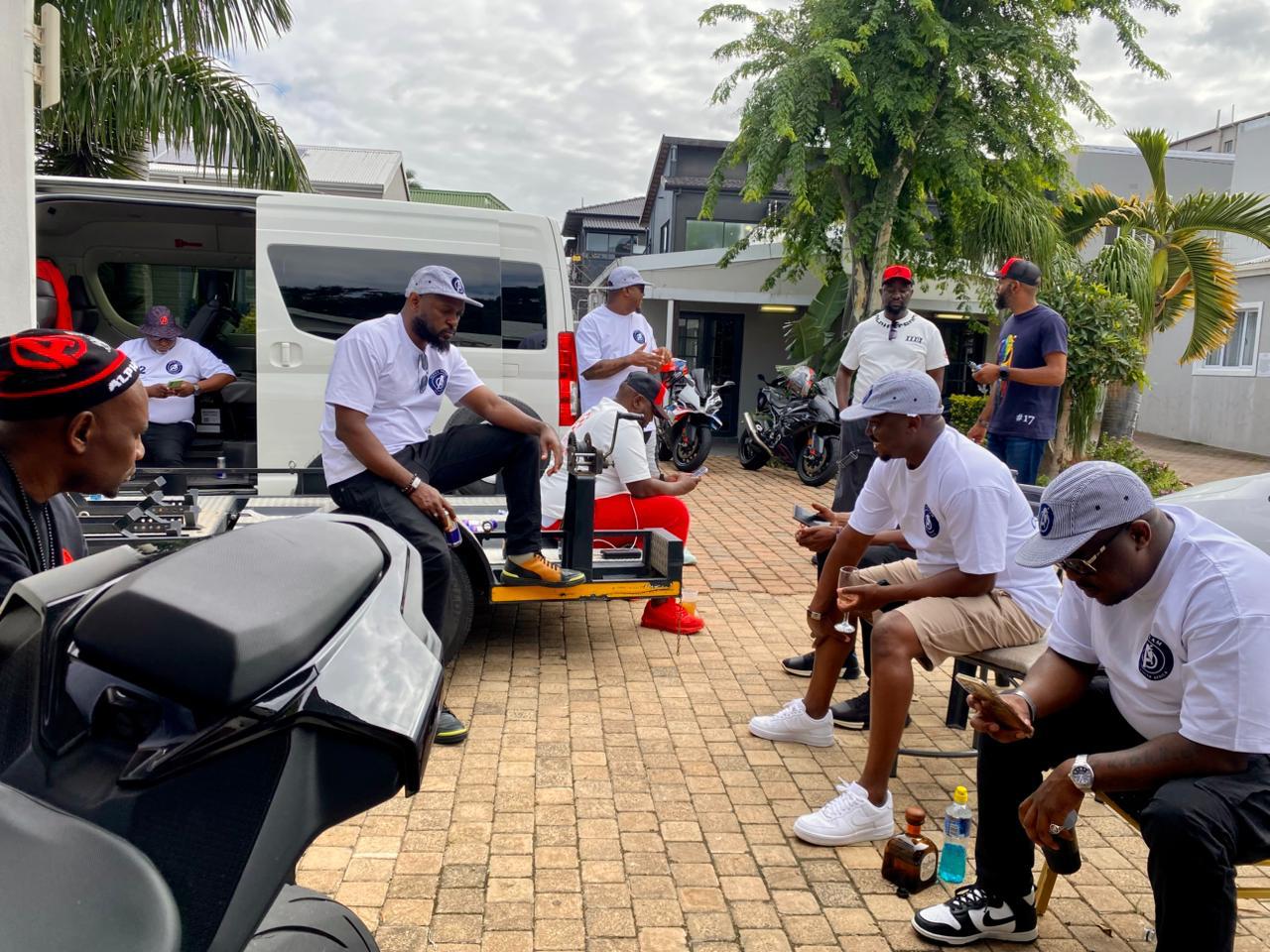 Alpha Team members gathered around a white van and bike trailer